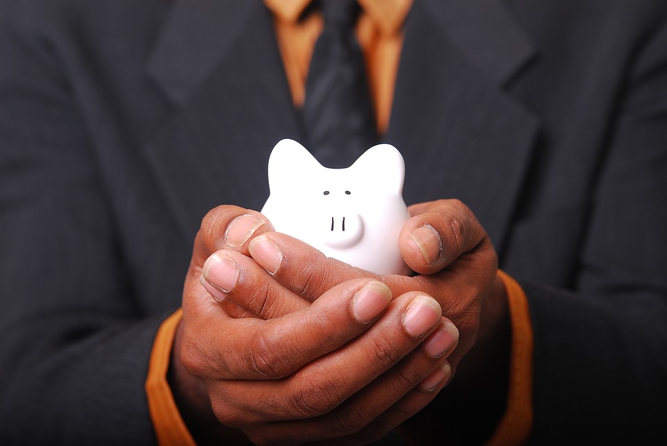 man in a suit with a piggy bank on his hands